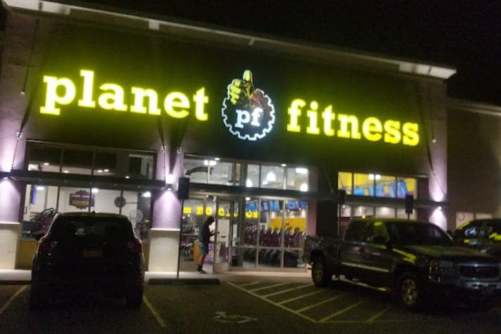 Planet fitness Los Lunas (1) A large neon sign for planet fitness.